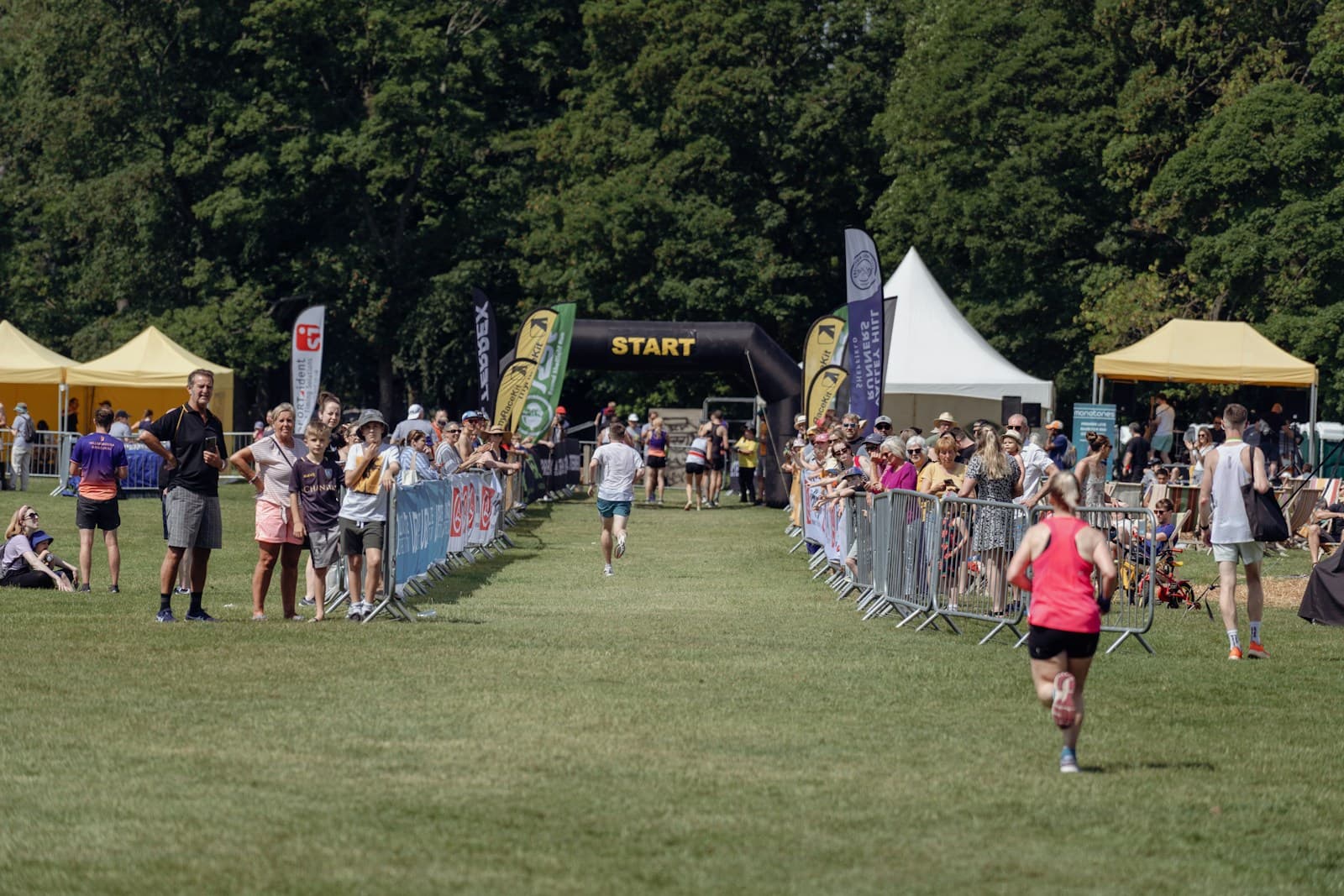 Группа бегунов на массовом забеге в парке — формат 5K parkrun